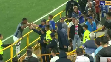 En la grabación se ve cómo la policía detiene al jugador brumoso para que no pegue al hincha